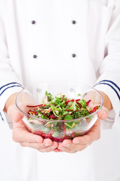 Hand holding a bowl of salad